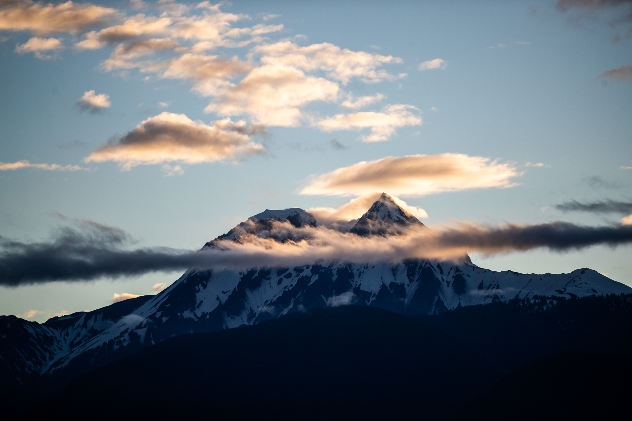 Snow-capped mountain peak glowing at sunset viewed from Howe Sound near Squamish BC